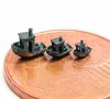 Benchmarkbauteile. Eine vergrößerte Fünfcent-Münze,auf der drei kleine schwarze Miniaturschiffe stehen. Größe: 3 bis 6 mm Länge bei einer Schichtdicke von 5 µm. 3D-Modell veröffentlicht von Creative Tools Sweden AB.
