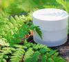 Cosmetic cream for skin care. Natural cosmetics in nature with green fern leaves.