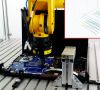 Ein Roboter steckt Flachkabel in eine Buchse auf einer Platine